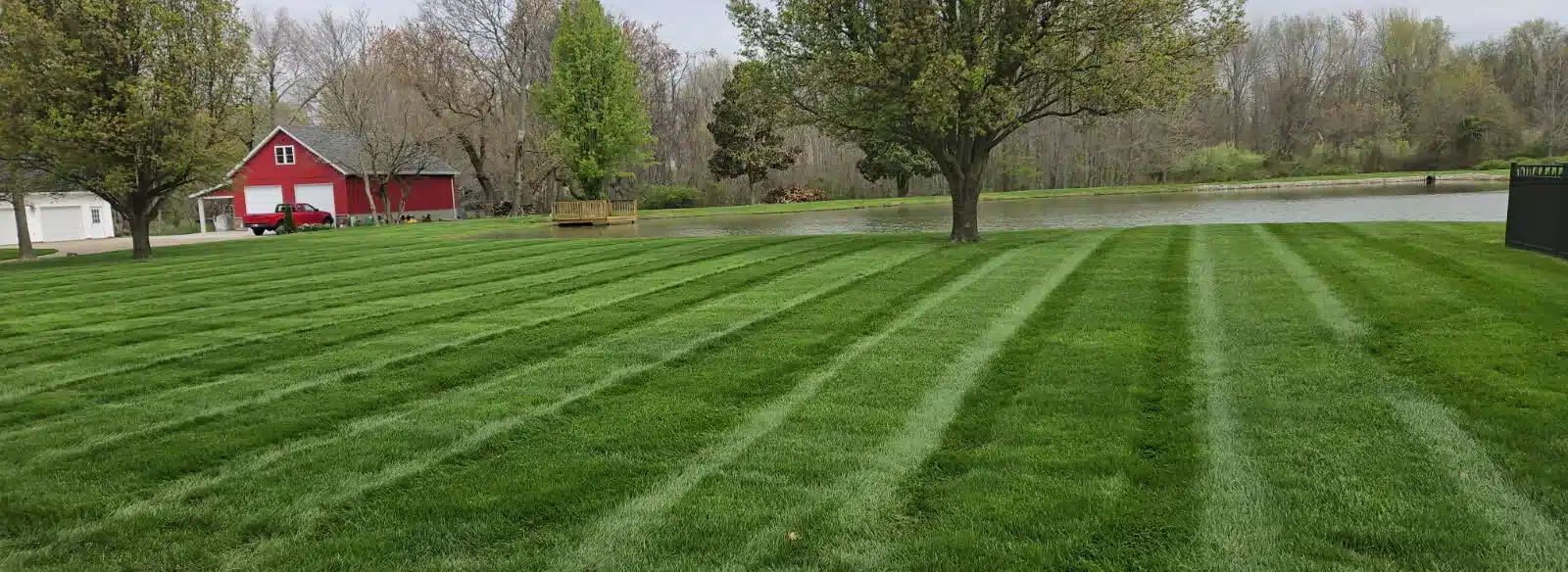 Wide lakeside yard freshly mowed after lawn care